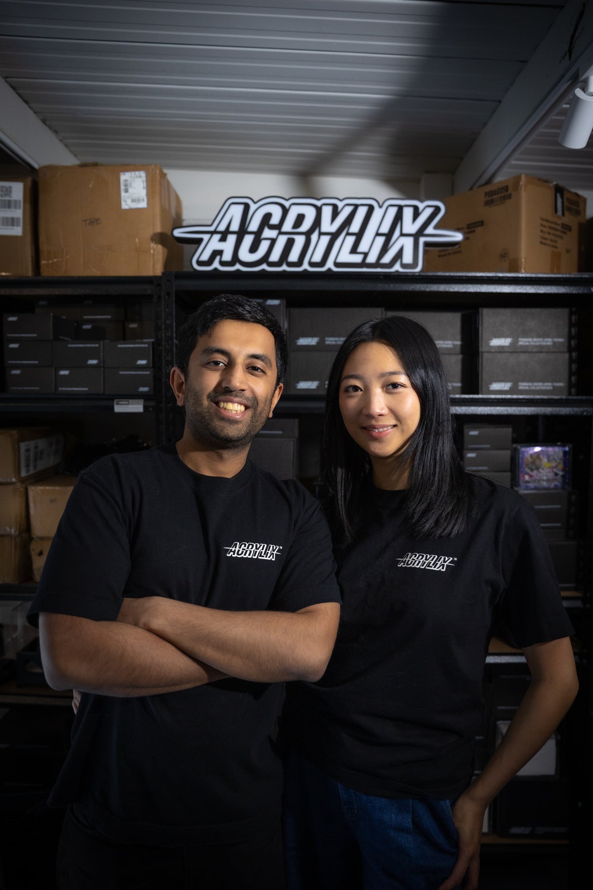 Rahil Chadha and Eastina Zhang, founders of ACRYLIX™, standing in front of the ACRYLIX™ sign and stock shelves