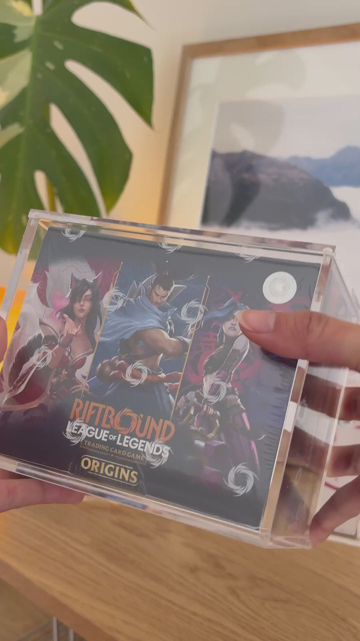 Riftbound booster box acrylic case holding Origins, placed on a stack – ACRYLIX