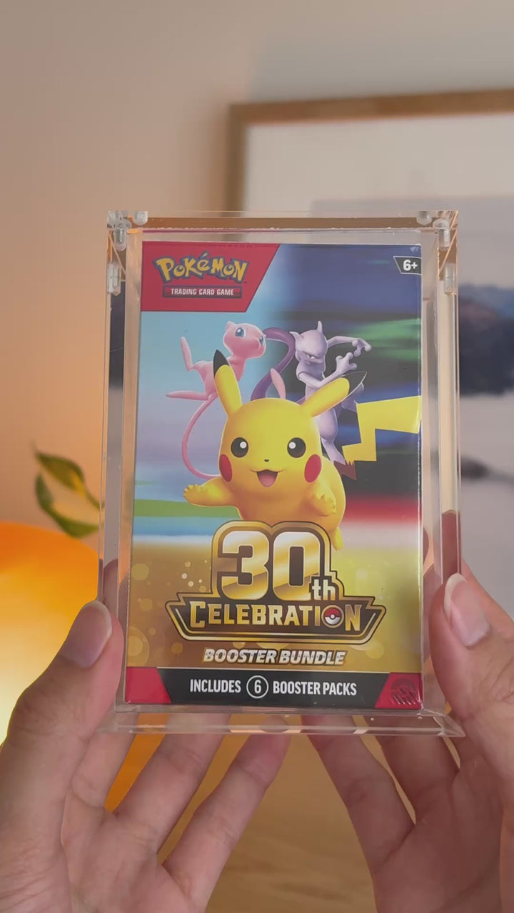 Pokémon booster bundle acrylic case (2026 onwards) holding 30th Celebration, held in hand – ACRYLIX